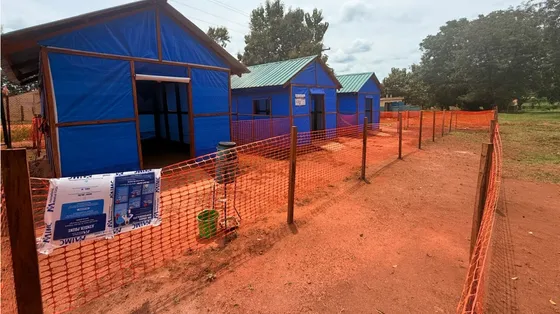 Una fila di baracche azzurre sulla terra rossa al confine tra Sud Sudan e Rdc