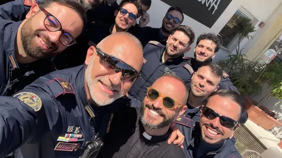 Foto di gruppo per alcuni agenti di polizia assieme a don Giovanni Giordano, cappellano alla Questura di Reggio Calabria