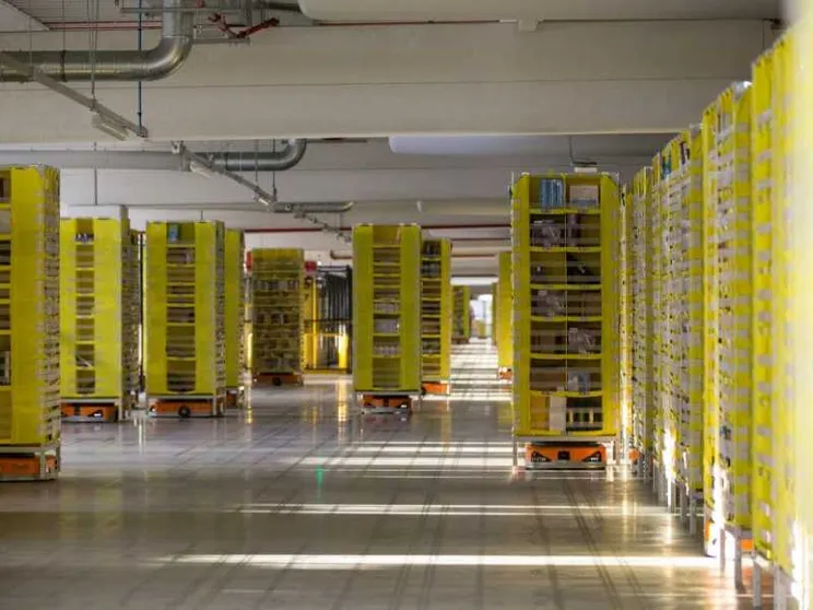 Uomini e macchine lavorano insieme nella base Amazon del Centro Italia