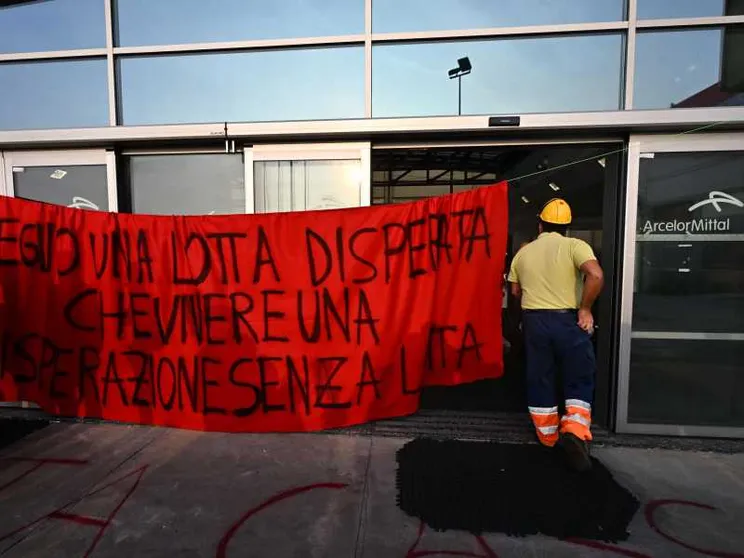Un operaio con uno striscione protesta per la sicurezza sul lavoro