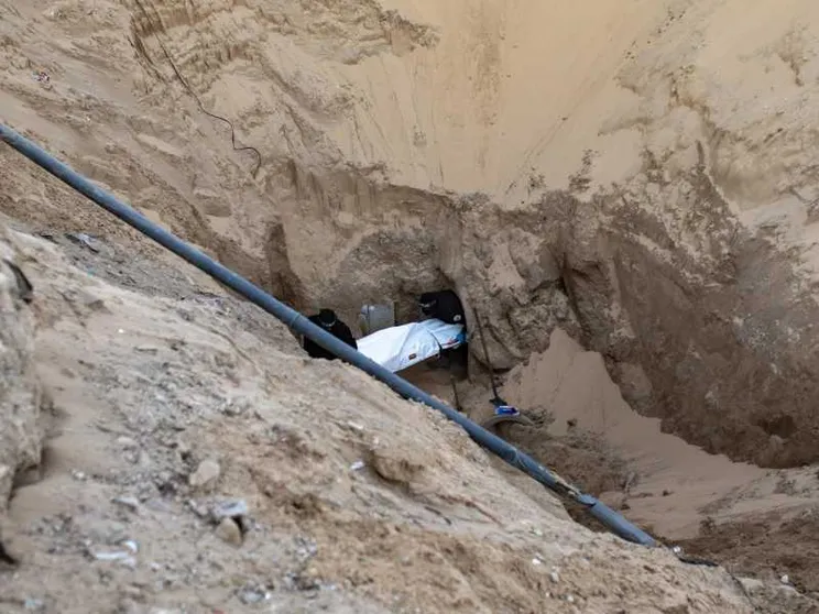 Miliziani di Hamas seppelliscono il corpo di un israeliano dopo averlo recuperato da un tunnel in Khan Yunis, nel sud di Gaza