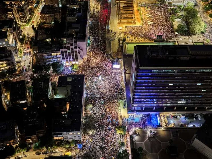 Nella fotografia, presa dall'alto da un drone, si vedono centinaia di migliaia di israeliani radunati di sera in Piazza Rabin a Tel Aviv per ricordare i 30 anni dall'assassinio del premier Yitzhak Rabin