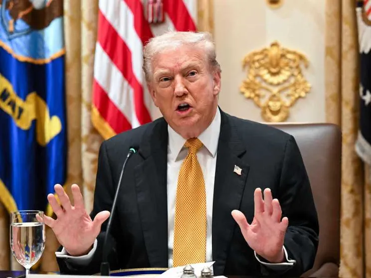 Un primo piano di Trump che mette le mani avanti, con i palmi aperti