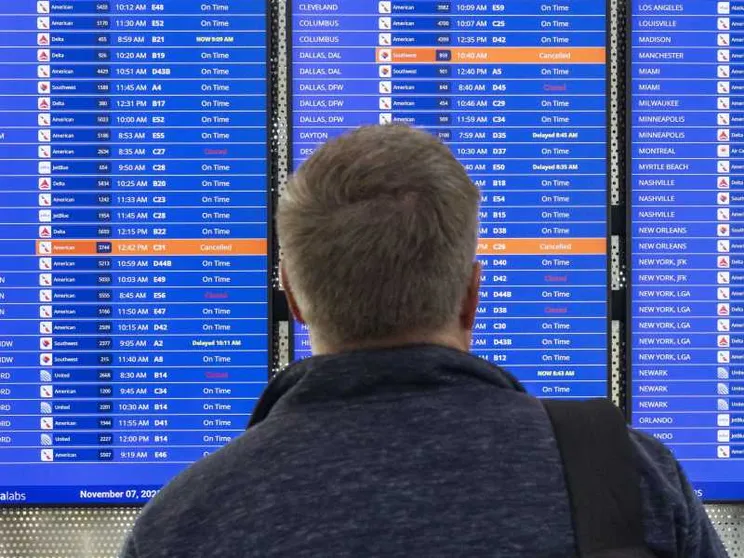 Un passeggero guarda il tabellone dove i voli Usa stanno ritornando regolari. Lo shutdown ha gettato nel caos il traffico aereo americano