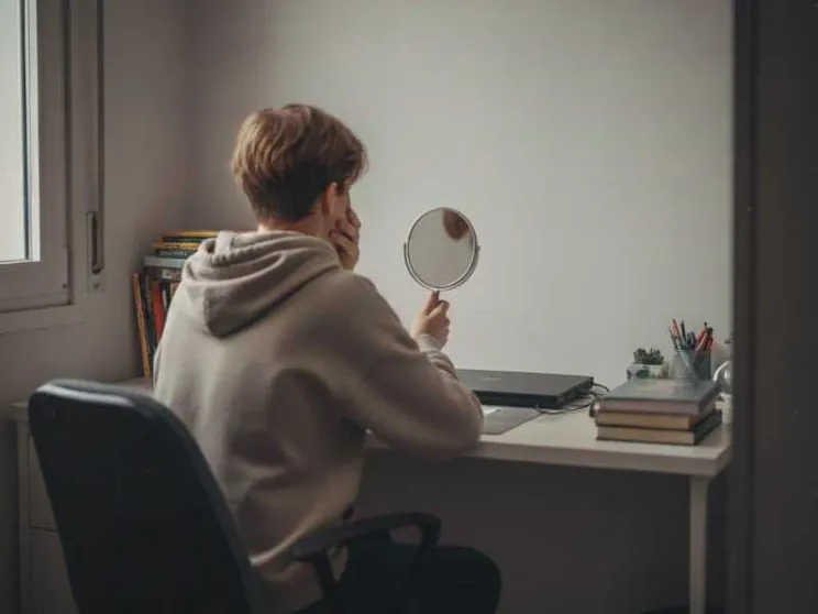 Un ragazzino si guarda allo specchio