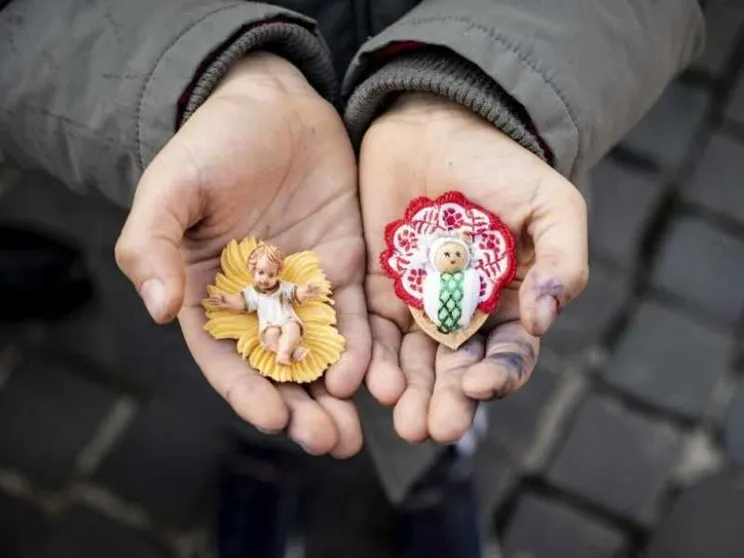 Le statuine di Gesù bambino in mano a un ragazzino in piazza San Pietro