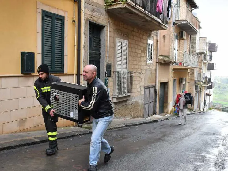Volontari della Protezione civile e comuni cittadini aiutano le persone a svuotare le proprie case in bilico sull'abisso, a Niscemi / ANSA