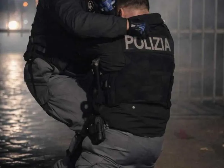Un agente di Polizia soccorso da un collega, durante gli scontri seguiti al corteo contro lo sgombero del centro sociale Askatasuna a Torino/ ANSA