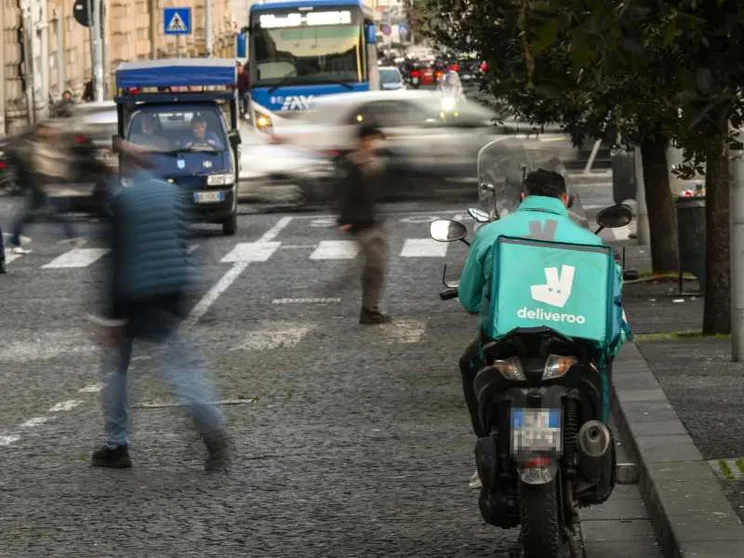 Un rider Deliveroo in attesa di chiamata a Napoli / Ansa