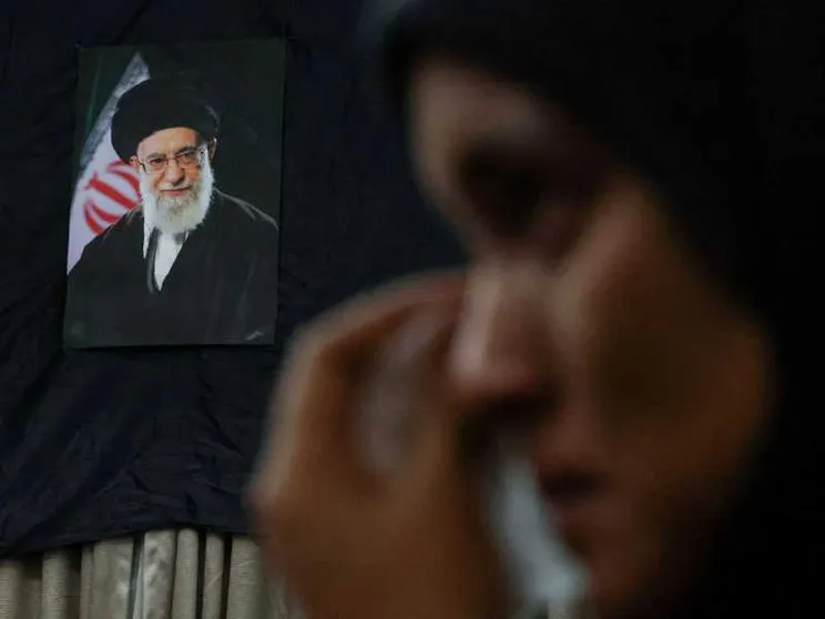 Una donna piange davanti alla foto dell'ayatollah Khamenei