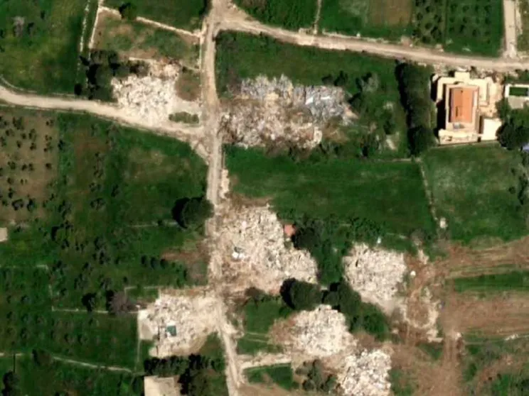 Un'immagine satellitare mostra varie chiazze bianche dove prima c'erano case e infrastrutture