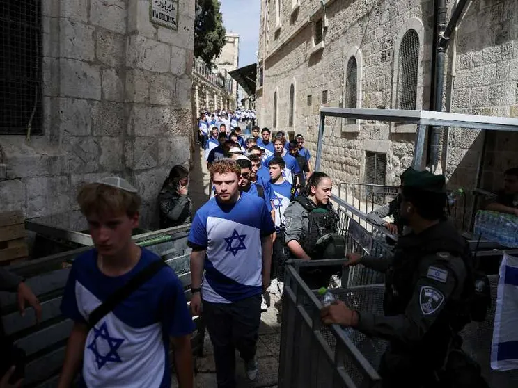 In un vicolo stretto della Città Vecchia una lunga fila di giovani che indossano magliette con la bandiera di Israele, bianche e celesti con la Stella di David, passano attraverso un controllo di polizia