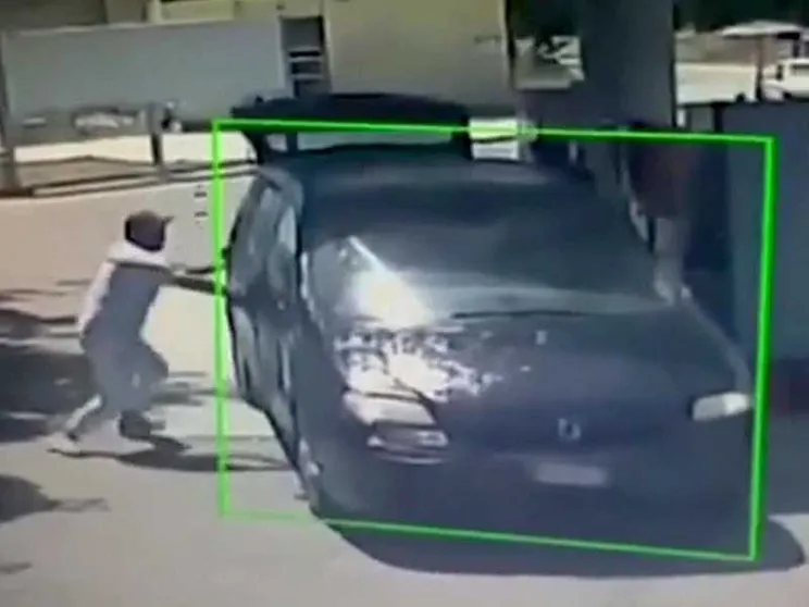 Un frame del video girato dall'impianto di videosorveglianza del distributore mostra due persone che bloccano le portiere dall'esterno facendo forza con le braccia, mentre dal portellone posteriore viene presumibilmente lanciato liquido infiammabile