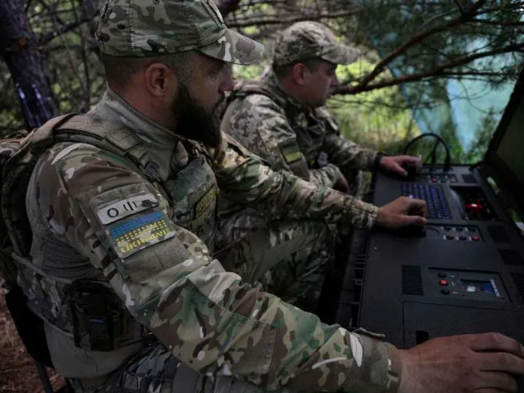 Due uomini in uniforme mimetica nel bosco