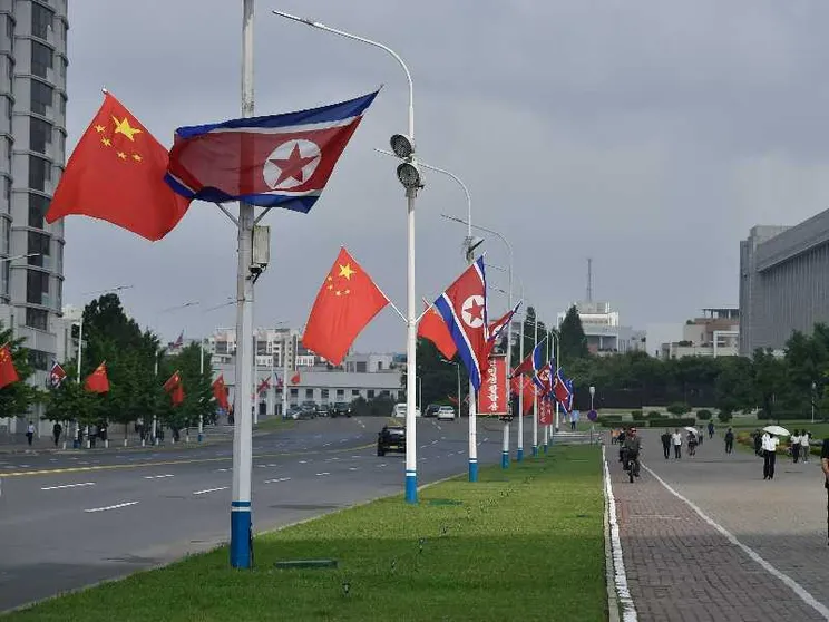 Le bandiere di Cina e Corea del Nord adornano le strade di Pyongyang in occasione della visita del presidente cinese Xi Jinping