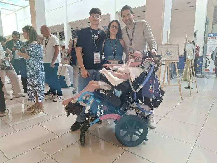 La famiglia Sciarretta con Noemi in carrozzina davanti alla mostra dei suoi quadri a ExpoAid a Rimini / foto Riccardi