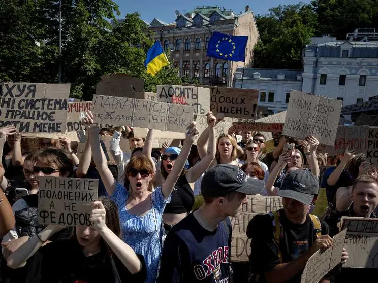 Gente in piazza a Kiev con cartelli scritti in ucraino di protesta per il licenziamento di Fedorov