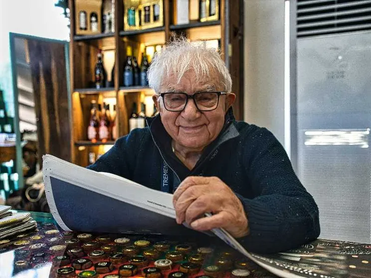 Una delle fotografie più recenti di don Mazzi, in mano un quotidiano