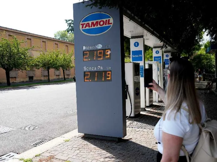 Una signora fotografa i prezzi del caro carburante