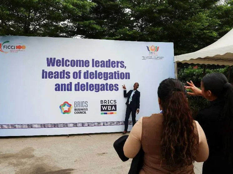 Delegati sudafricani scattano foto all'esterno del Bharat Mandapam, la sede che ospita il 18esimo vertice dei Brics a New Delhi