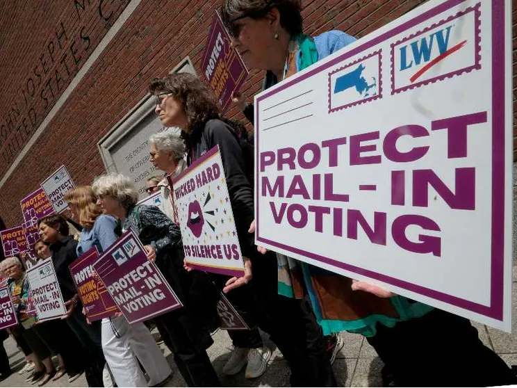 Persone protestato con dei cartelli su cui è scritto: protect mail - in voting