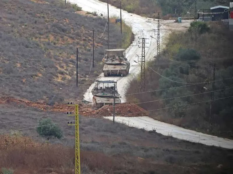 Una strada in terra battuta su cui passano due carroarmati