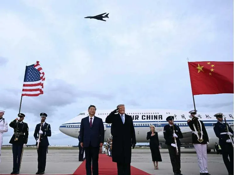 Il presidente degli Stati Uniti Donald Trump reagisce al passaggio di un bombardiere B-1 durante gli inni nazionali, mentre accoglie il presidente cinese Xi Jinping al suo arrivo alla Joint Base Andrews