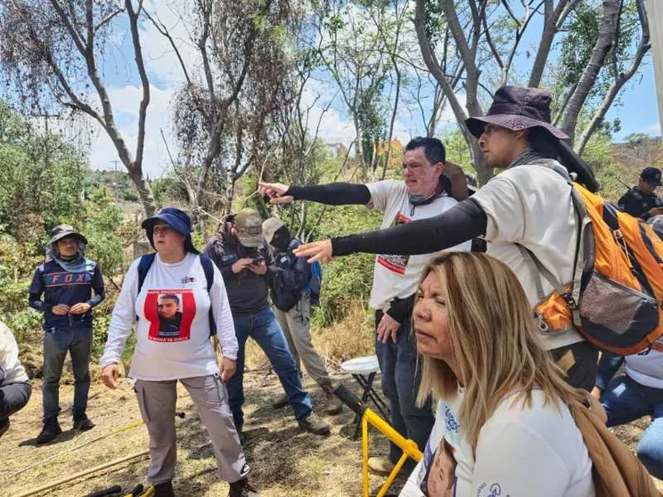 Familiari cercano in uno sterrato alla periferia di Guadalajara. Indossano magliette bianche con le foto dei parenti scomparsi