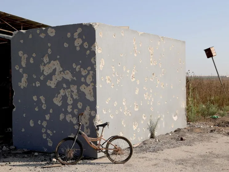 Una bicicletta appoggiata alla parete crivellata di proiettili di un rifugio antiaereo in cemento, fuori dal kibbutz Nahal Oz