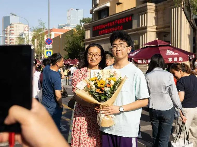 Studenti delle scuole superiori e le loro famiglie posano per le foto dopo aver sostenuto il Gaokao a Pechino nel 2025