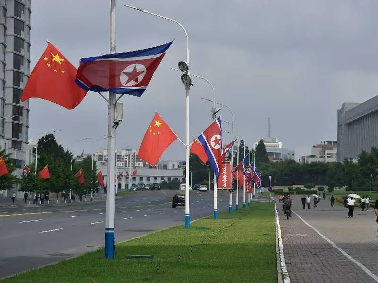 Le bandiere di Cina e Corea del Nord adornano le strade di Pyongyang in occasione della visita del presidente cinese Xi Jinping