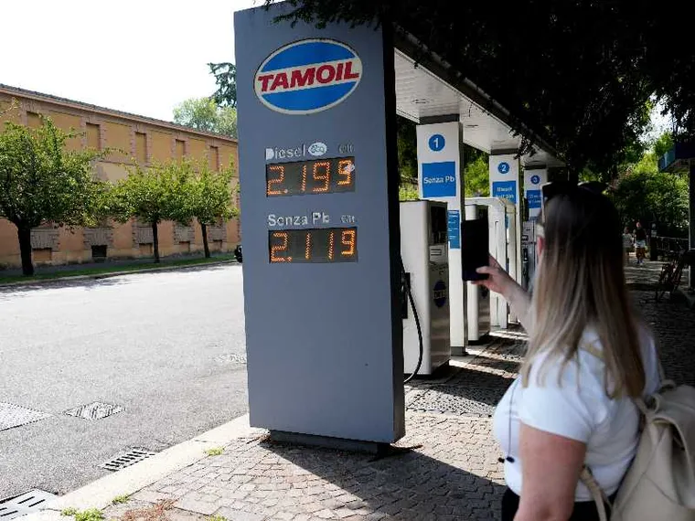 Una signora fotografa i prezzi del caro carburante