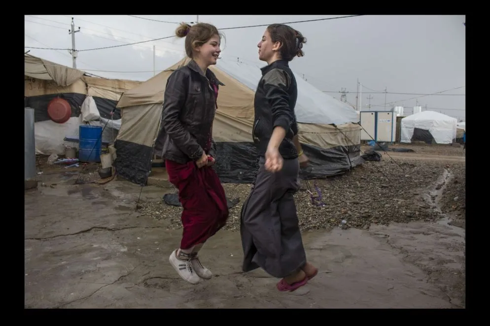 Nell'agosto 2014 oltre 400mila componenti della comunità yazida hanno dovuto abbandonare le loro case mentre Daesh conquistava, devastandole, ampie estensioni di territorio iracheno. Molti di loro sono stati fatti prigionieri e giustiziati, migliaia di donne e bambini sono stati ridotti in schiavitù. Chi è riuscito a fuggire si è rifugiato sulle montagne di Sinjar, per poi raggiungere i campi profughi della regione del Kurdistan iracheno. Il campo profughi di Khanke – il luogo dove sono ospitate le ragazze che sono anche le autrici delle fotografie e da cui provengono gli stessi scatti – ospita quasi 3mila famiglie, fuggite dalla provincia irachena di Ninive. Nonostante il trauma e gli orrori a cui ha assistito, la comunità yazida ha dimostrato caparbietà e una grande capacità di reagire, di cui la mostra fotografica è un toccante esempio.