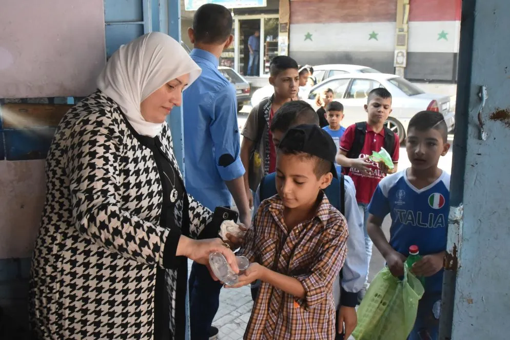 Studenti si disinfettano le mani prima di entrare in classe a Damasco, in Siria. La scuola è iniziata il 5 settembre