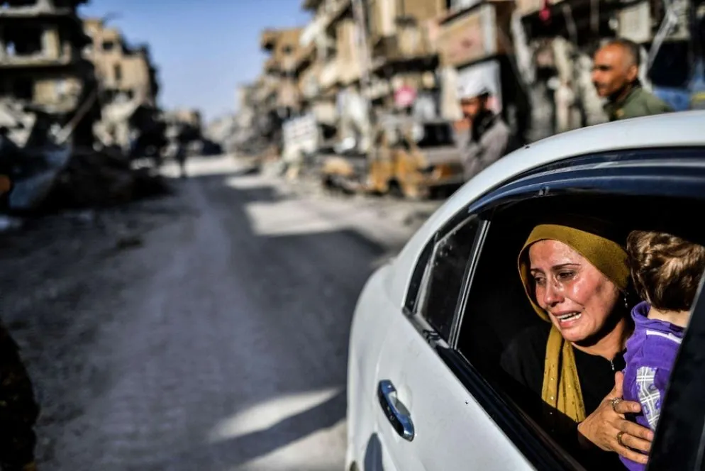 Madre e figlio lasciano la loro casa a Raqqa nel 2017