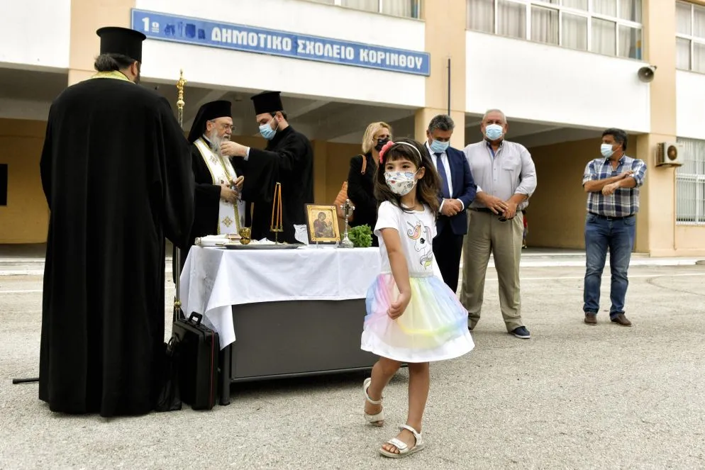 Una bambina balla durante una tradizionale cerimonia per l'inizio della scuola a Corinto, in Grecia