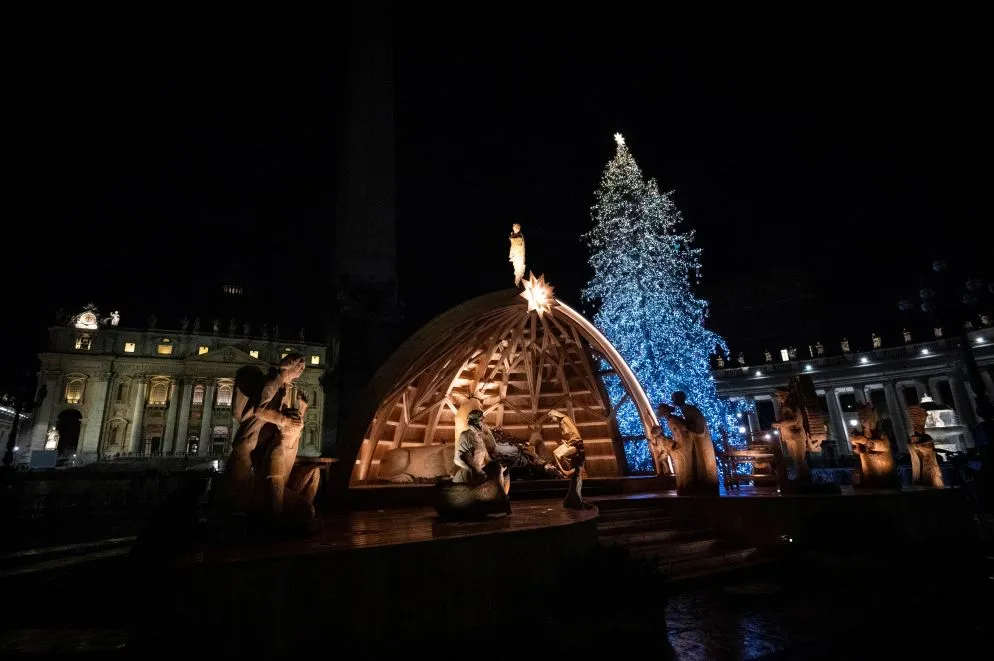 Undici scultori del legno, artisti che arrivano da tutto il territorio del Friuli Venezia Giulia, si sono dedicati negli ultimi due anni all’intaglio del classico Presepe in piazza San Pietro a Roma. Disposto su una superficie di 116 mq, conta 18 statue illuminate da 50 punti luce, la cupola della semisfera che fa da grotta, sovrastata dall’angelo, tocca un’altezza di 7 metri. E' un presepe focalizzato sui valori della sostenibilità, nessun albero è stato abbattuto per le statue in legno di cedro e la struttura realizzata con 24 metri cubi di legno di larice. Nella grotta trova posto la Sacra Famiglia, intorno alla quale sono collocati personaggi a grandezza naturale che, oltre alle figure della natività, rappresentano personaggi comuni. Tra loro, il falegname, intento al lavoro su un banco, in onore di tutti gli artigiani del paese di Sutrio, una tessitrice, tipico mestiere femminile della Carnia; il “Cramar”, rappresentante di un'antica professione di commerciante ambulante e una pastora con al fianco due pecore e una “gerla, la classica cesta usata dalle donne in montagna. Ci sono anche due figure simboliche: un uomo aiuta l’altro a risollevarsi per rimettersi in cammino versa la grotta: vuole ricordare la solidarietà che viene soprattutto praticata in ambienti come la montagna. Non potevano mancare, infine, i Re Magi.