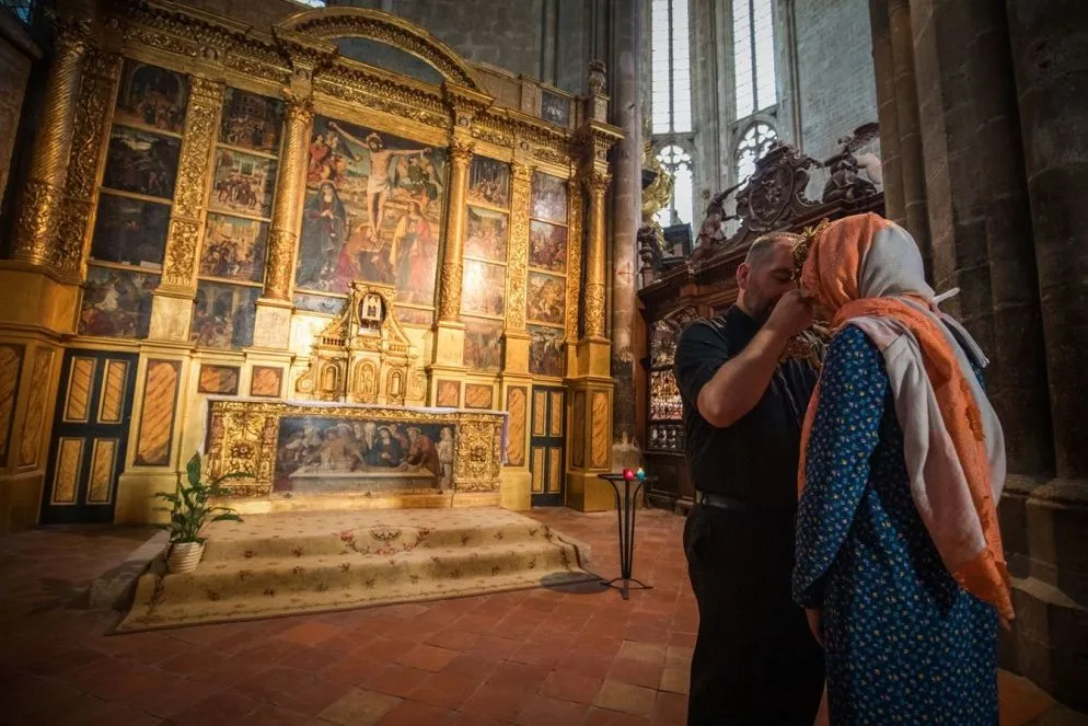 Un sacerdote benedice un pellegrino con le reliquie di Maria Maddalena