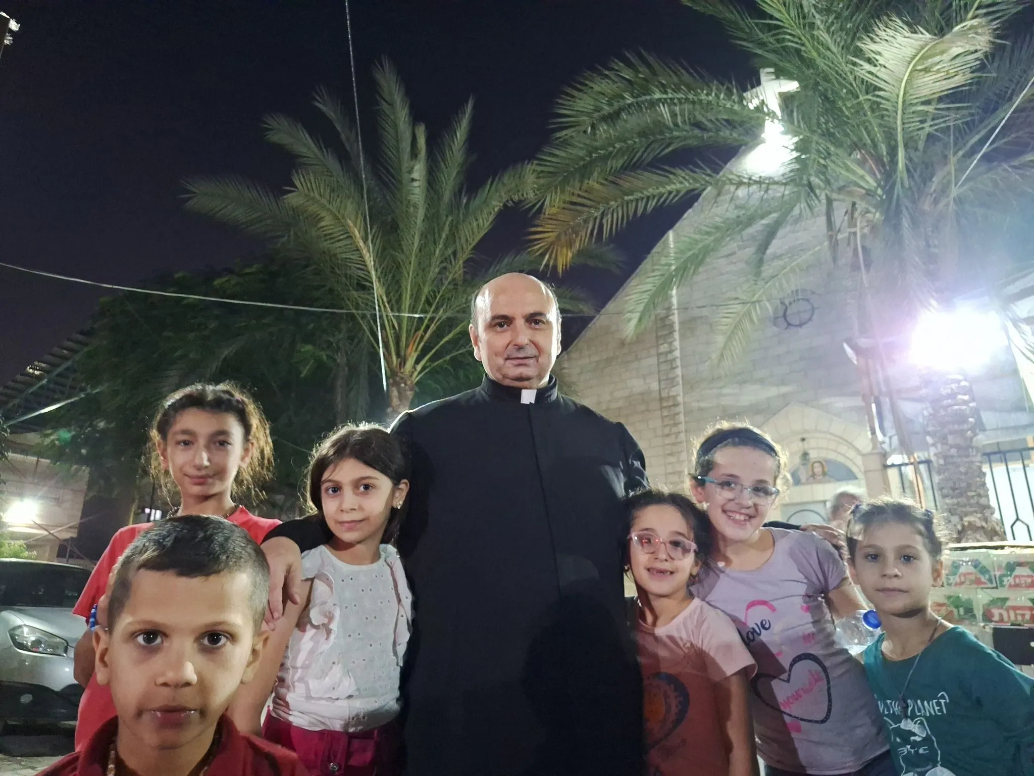 Don Gabriele Romanelli con alcuni bambini della parrocchia (dalla pagina Facebook di padre Gabriel Romanelli)