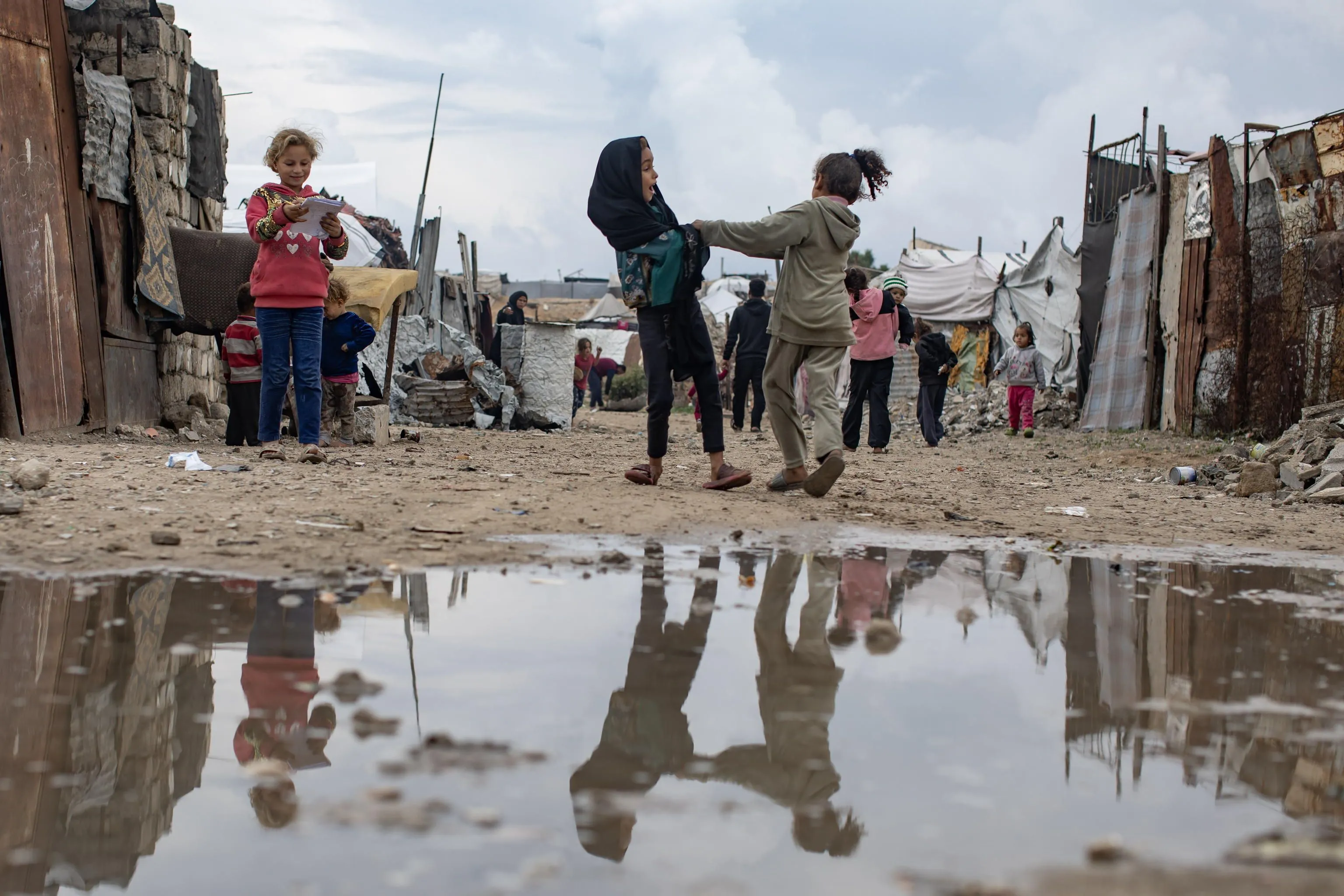 Bambini palestinesi sfollati davanti alle loro tende a Khan Yunis, nella Striscia di Gaza meridionale. Riescono a giocare, ma le loro condizioni sono estreme. E sono sempre più esposti a gravi infezioni, soprattutto a causa dell'acqua contaminata, e a malattie, aggravate dal freddo /Ansa