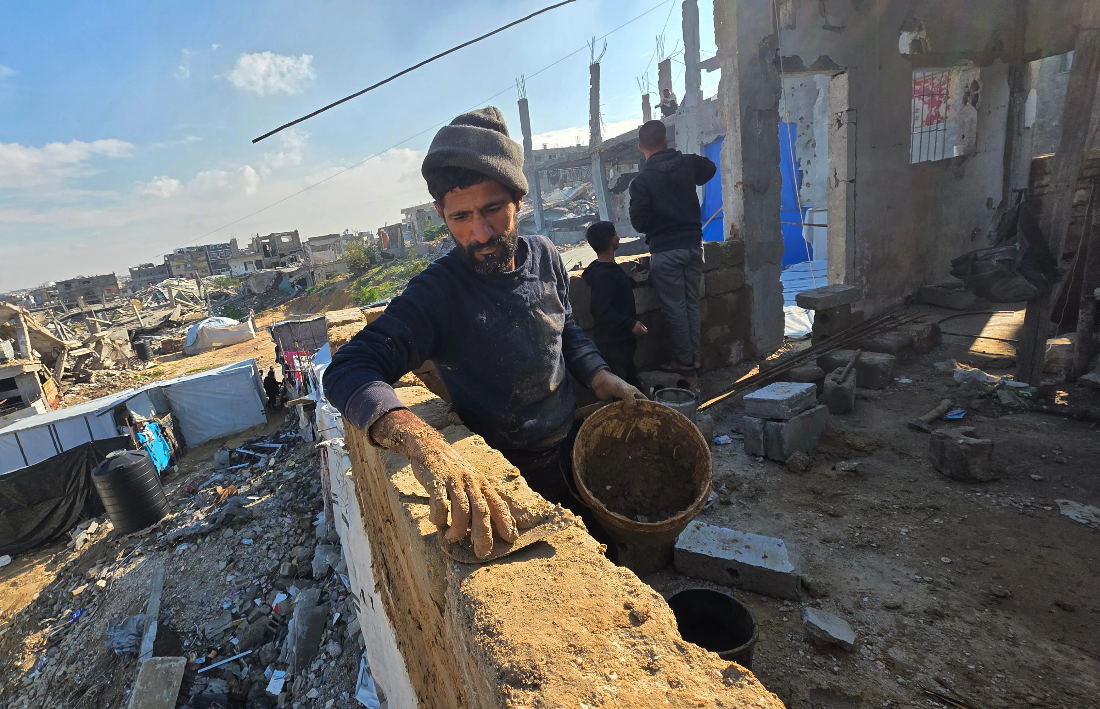 Per qualche ora ha smesso di piovere e i palestinesi di Khan Yunis hanno iniziato a costruire ripari di fango, utilizzando strumenti e metodi rudimentali, per cercare di garantirsi una protezione dal freddo invernale /Fotogramma