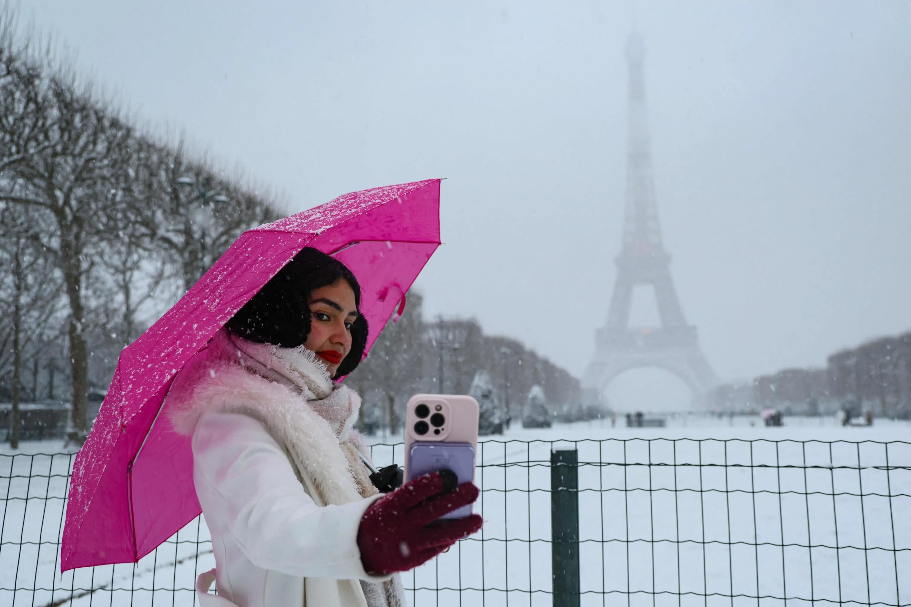 Selfie con la magia della Tour Eiffel imbiancata / AFP   