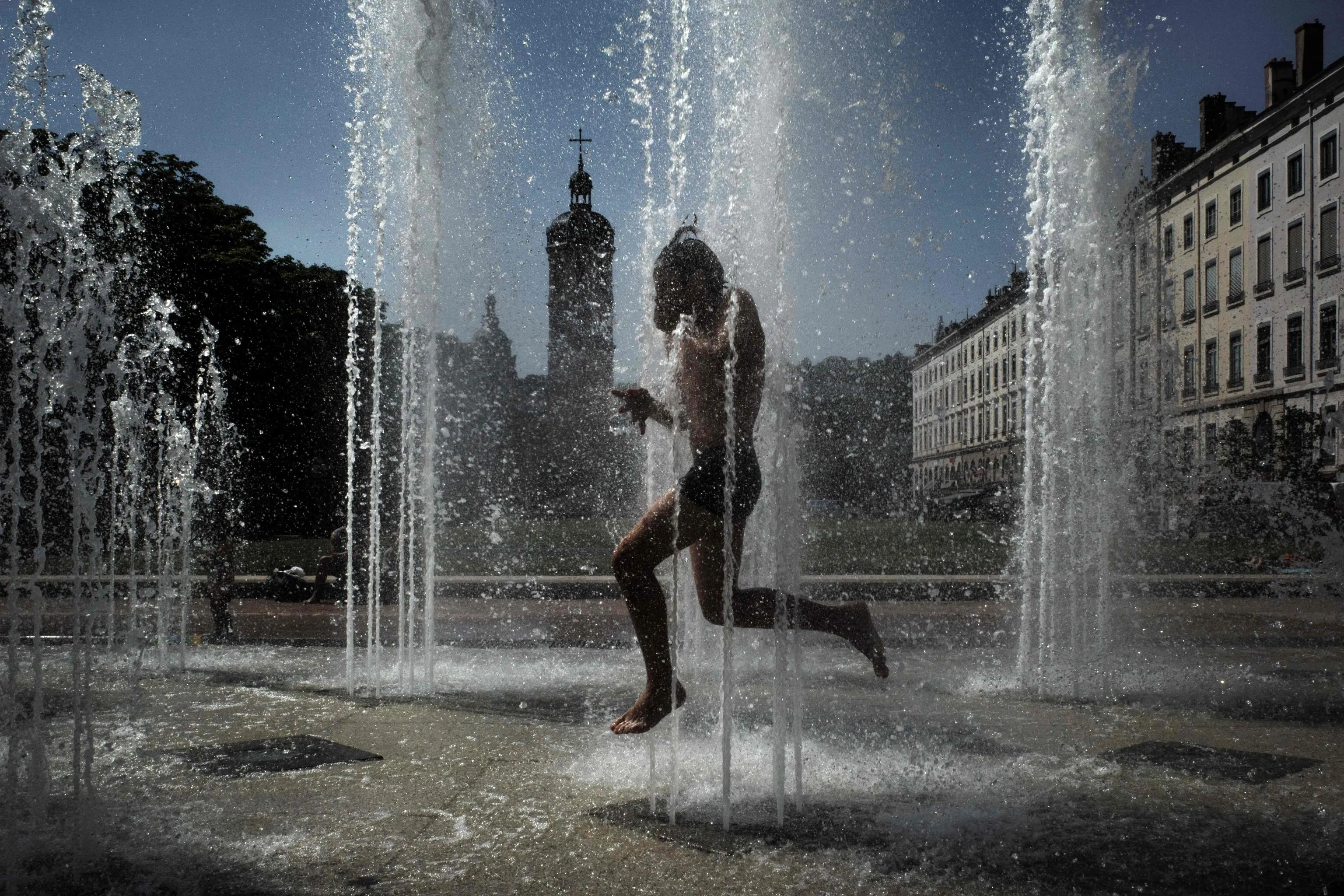Un bambino si rinfresca in una fontana a Lione, in Francia /ANSA