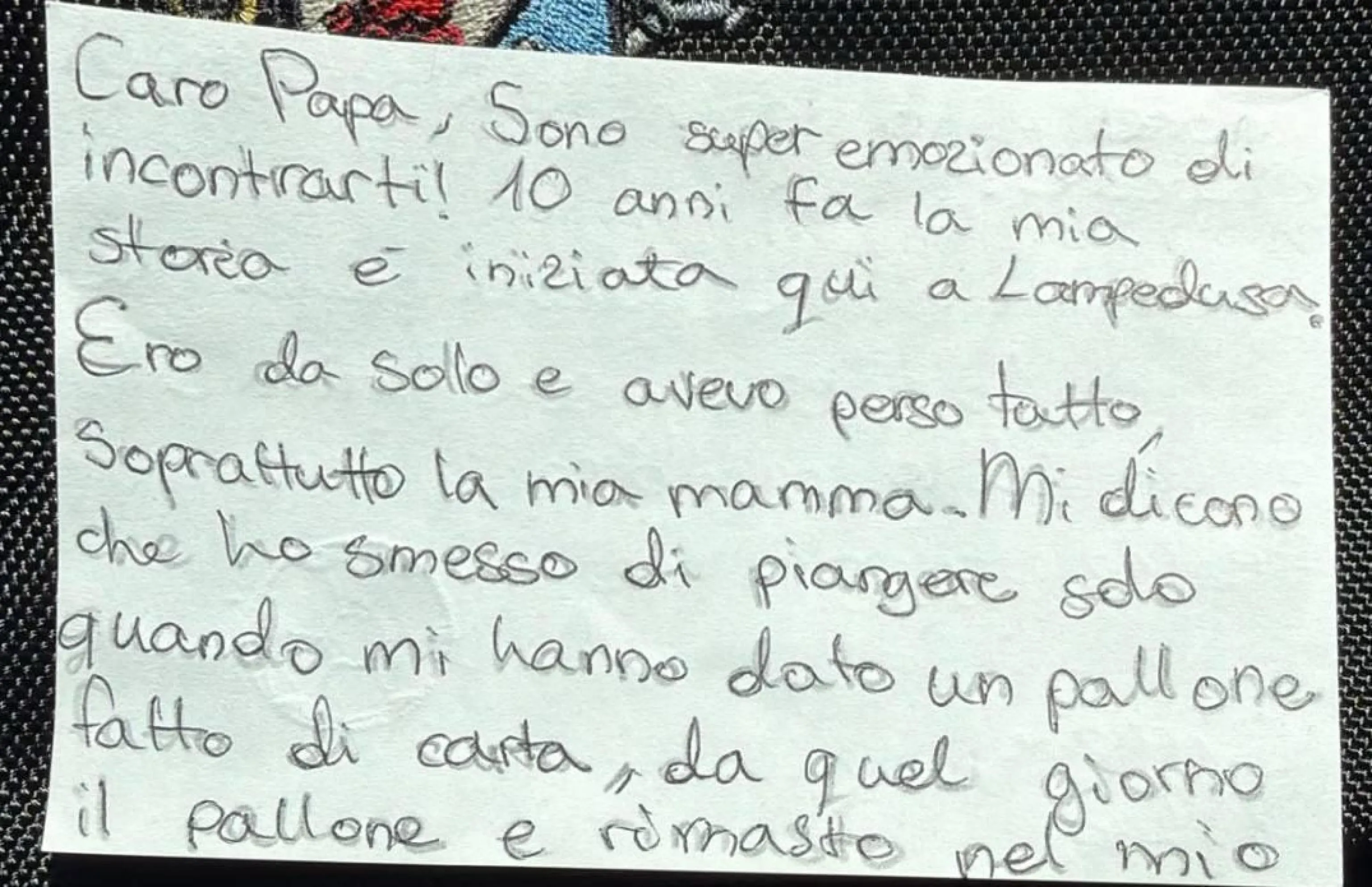 La letterina che il piccolo Leo ha consegnato, insieme a un pallone, a papa Leone alla porta d'Europa: "Caro Papa - si legge - sono super emozionato di incontrarti! 10 anni fa la mia storia è iniziata qui a Lampedusa. Ero da solo e avevo perso tutto, soprattutto la mia mamma. Mi dicono che ho smesso di piangere solo quando mi hanno dato un pallone fatto di carta, da quel giorno il pallone è rimasto nel mio cuore e io non ho smesso di giocare. Spero tanto che questa palla che ti regalo adesso possa arrivare a un altro bambino e farlo felice proprio come me. Grazie, Leo" / Ansa - Sala stampa della Santa Sede