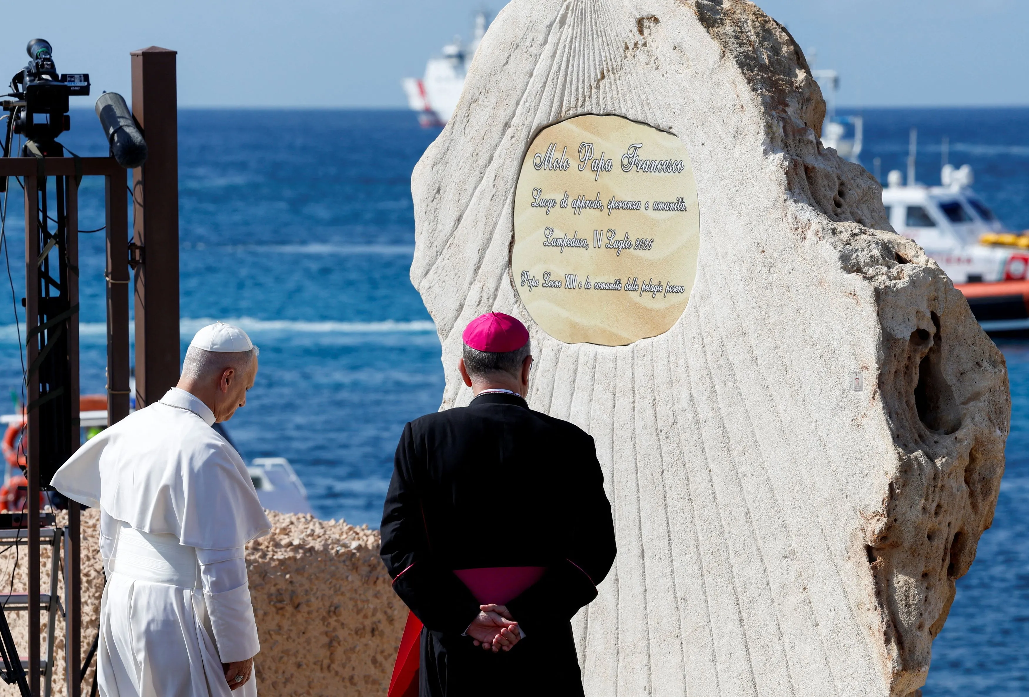 Leone XIV ha raggiunto il pontile degli sbarchi, insieme all'arcivescovo di Agrigento. Qui ha salutato alcuni migranti e ha benedetto la targa che intitola il molo a papa Francesco che aveva visitato l’isola nel 2013 / Reuters_Remo Casilli