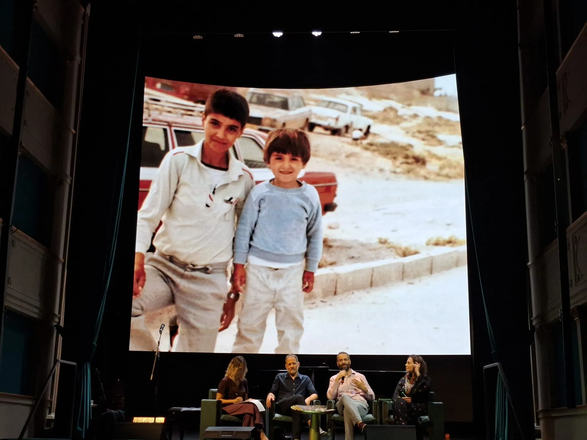 Aziz Abu Sarah con il fratello in una foto proiettata al Teatro Nazionale. In basso, da destra Mira Awad, Aziz Abu Sarah, Maoz Inon e la traduttrice dell'incontro