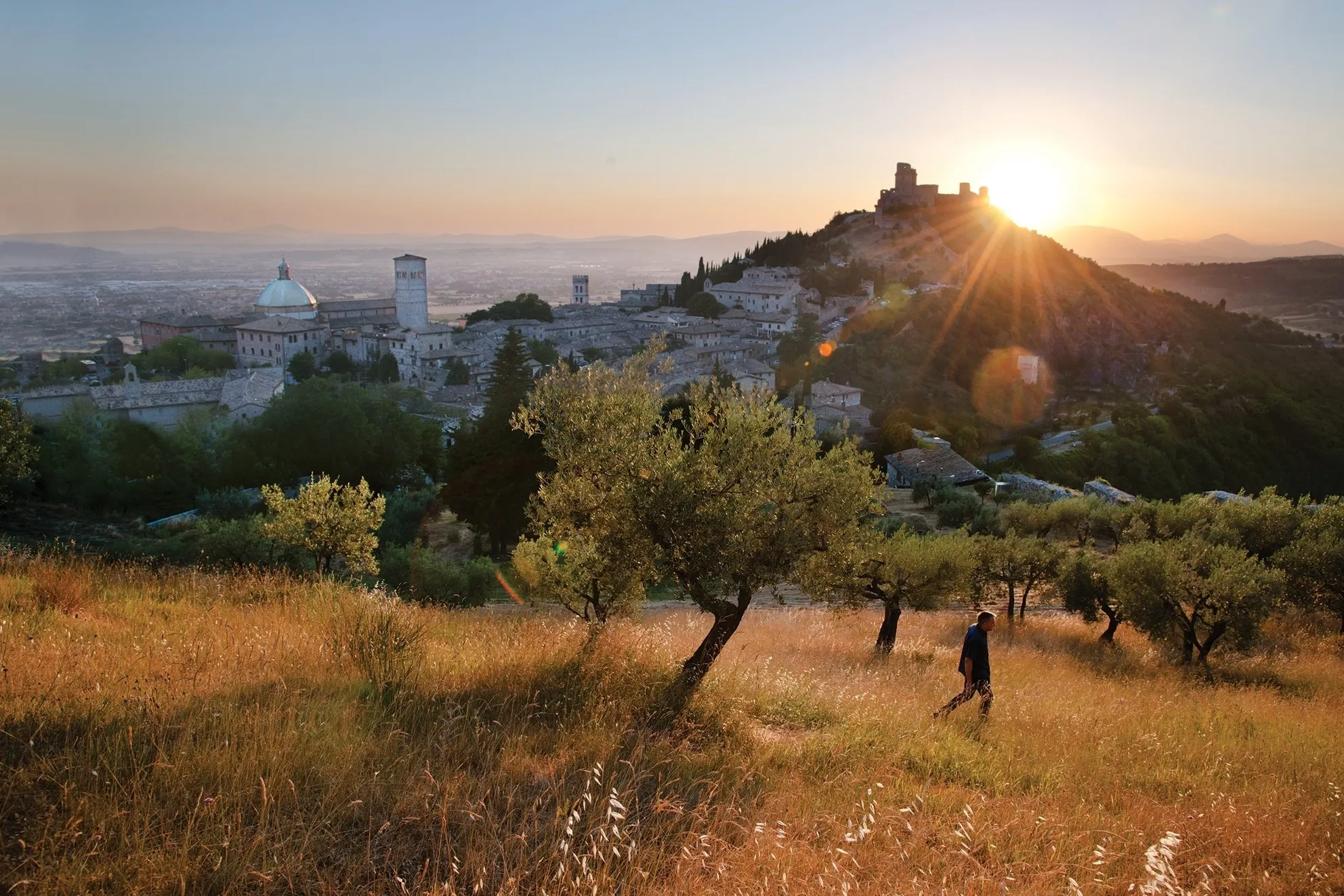 Un uomo cammino nelle campagne di Assisi, sullo sfondo la Rocca Maggiore, Italy, 2012 © Steve McCurry 
