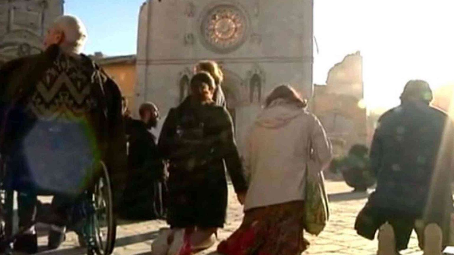 In ginocchio di fronte alla basilica sventrata