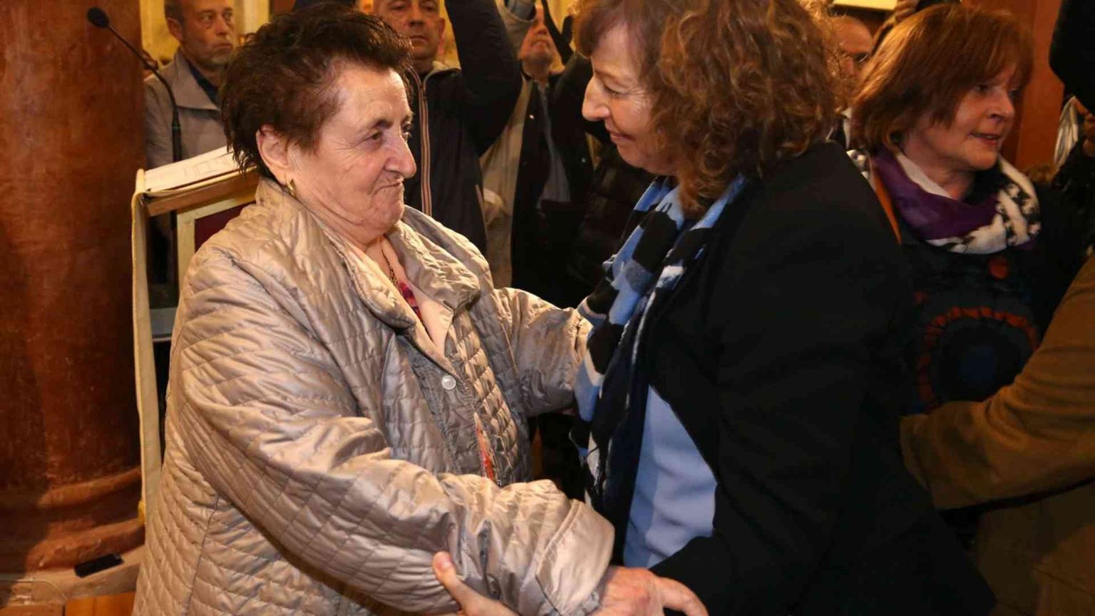 L'abbraccio fra i parenti del martire e la figlia del partigiano che lo uccise