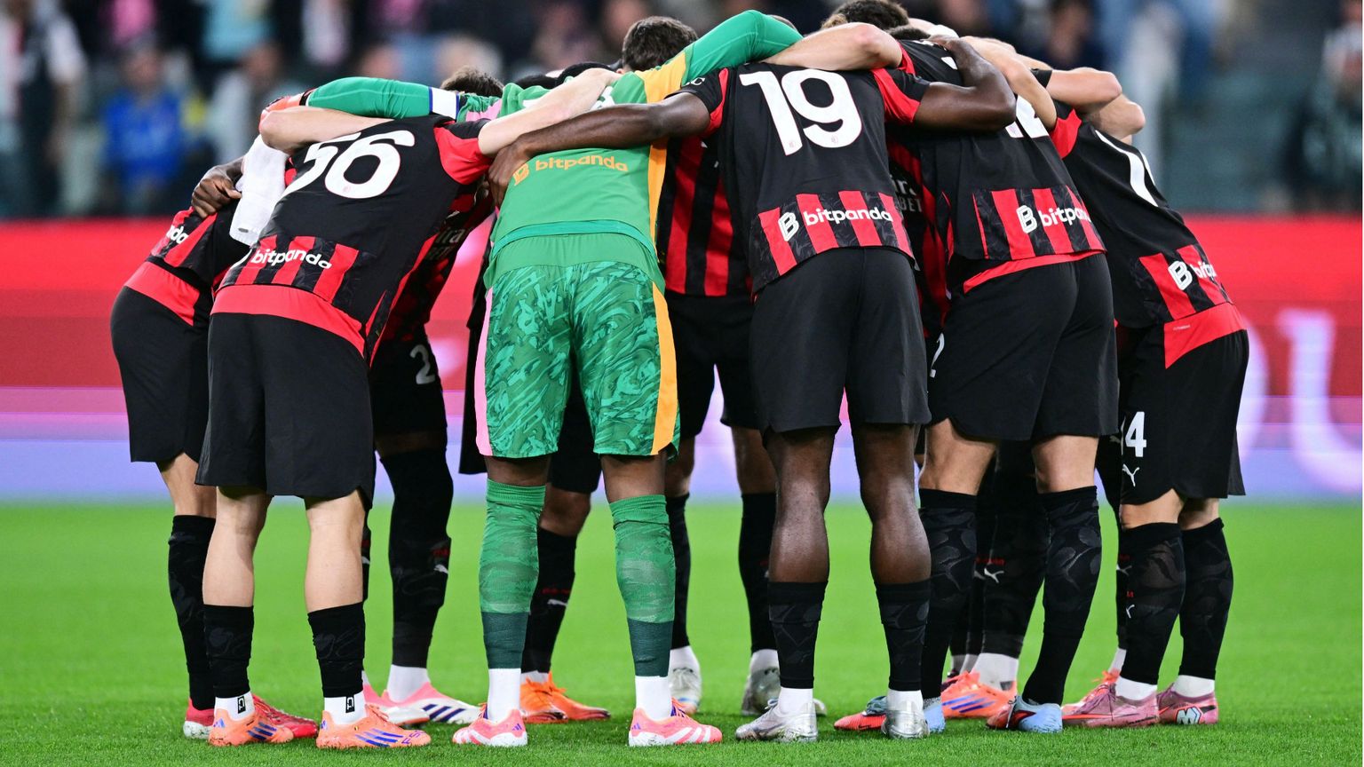 Giocatori del Milan in maglia rosonera radunati a centrocampo prima della partita